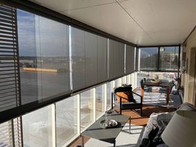 Sun protection roller blinds in a glazed balcony