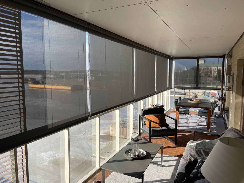 Sun protection roller blinds in a glazed balcony